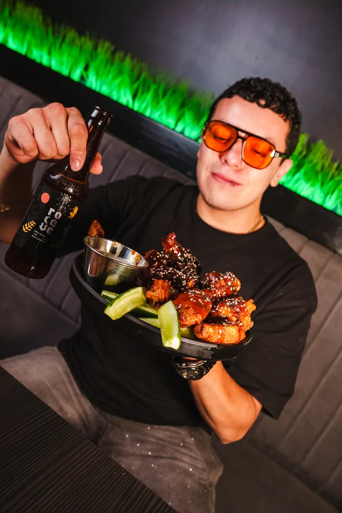 Foto real: cerveza Rocave junto a un plato de boneless en Del Abuelo